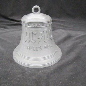 May include: A silver bell with the words "AC/DC" and "Hell's Bell" engraved on it.