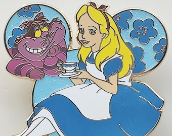 May include: A Disney-themed pin featuring Alice in Wonderland. Alice, in her blue dress, holds a teacup, with the Cheshire Cat beside her. The pin is shaped like Mickey Mouse ears, with a light blue background and floral accents.
