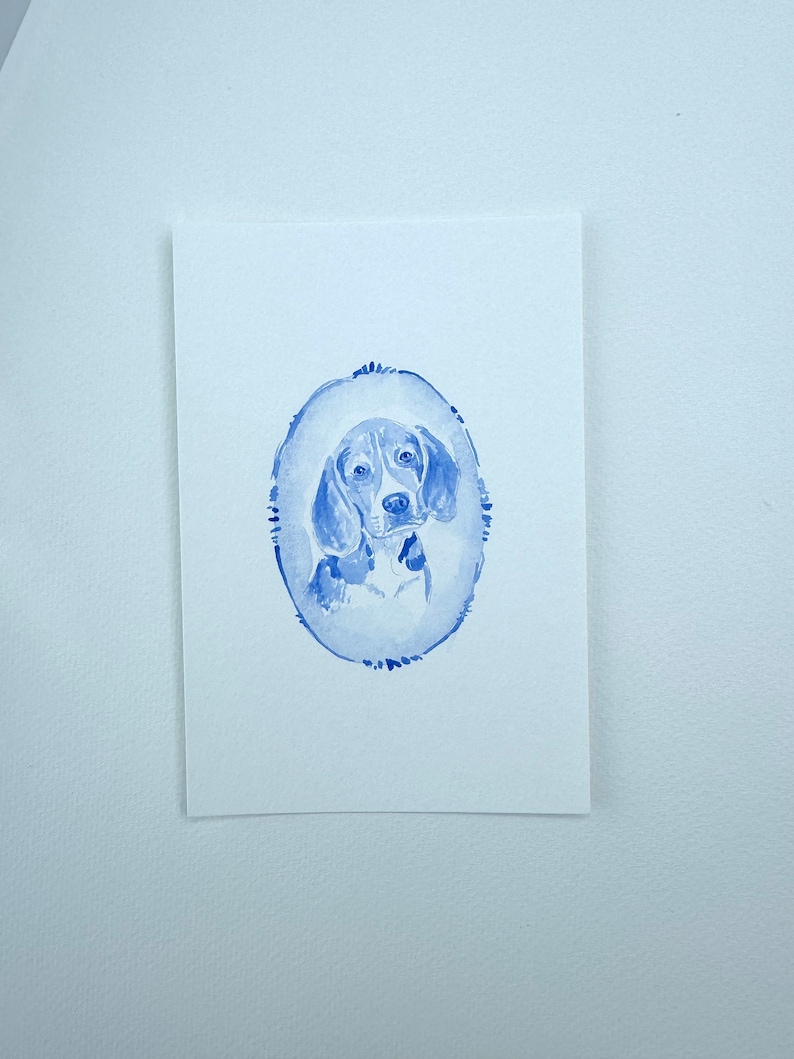 May include: A watercolor painting of a beagle dog in a blue oval frame. The dog is looking directly at the viewer with a serious expression.
