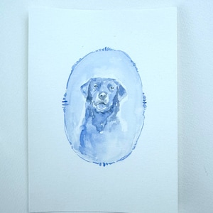 May include: Watercolor painting of a black Labrador Retriever in a blue oval frame.