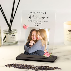 May include: A clear glass photo frame with a black base. The frame has a photo of two women hugging and the text "You are the Mum that everyone wishes they had".