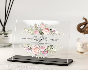 May include: A clear acrylic plaque with a floral design and Arabic calligraphy. The plaque has a black stand and the text reads "Ahmed & Nadia وحلفتكم اروجا . And We created you in pairs" QUR'AN 78:8 30.03.2024