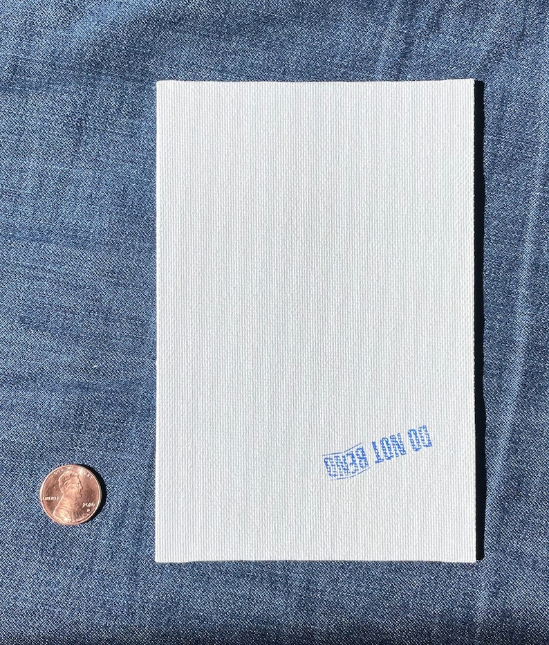 May include: A white, textured notebook with a blue stamp that reads "CO NOT BEND".