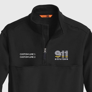 May include: Black quarter-zip sweatshirt with a mock neck and a small logo on the chest. The logo includes the text "DISPATCHER" and the words "CUSTOM LINE 1" and "CUSTOM LINE 2".