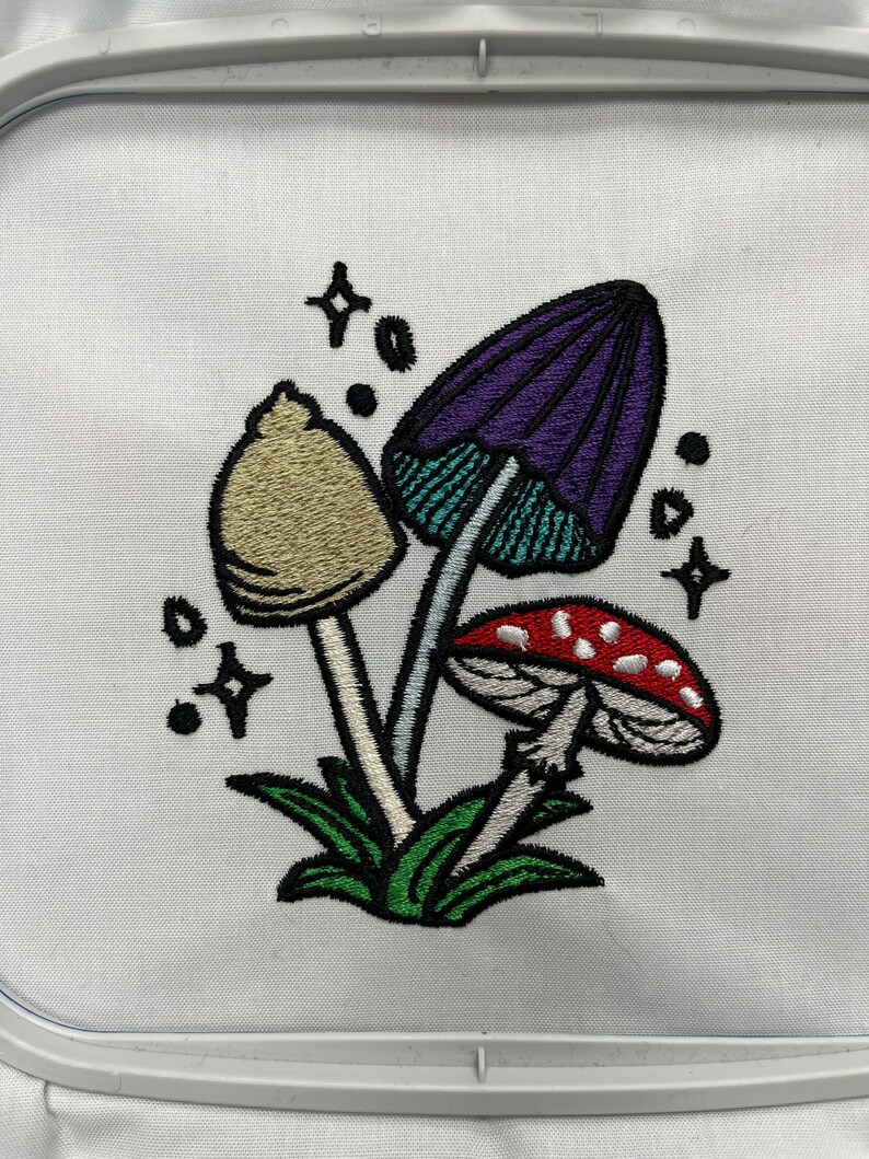 Magical mushroom cluster embroidery file in a fantasy fairy garden. Cute mushrooms from a magical garden. Completed stitch sample to so quality and details.
