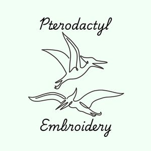 May include: Line art illustration of two pterodactyls flying, with the text "Pterodactyl Embroidery" below.