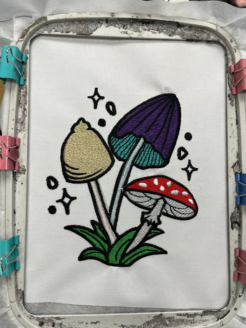 Magical mushroom cluster embroidery file in a fantasy fairy garden. Cute mushrooms from a magical garden. Completed stitch sample to so quality and details.