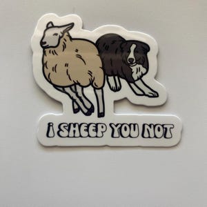 May include: A white sticker with a black and white cartoon image of a sheep and a dog. The text "i sheep you not" is written in black below the image.