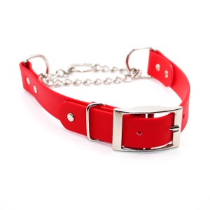 May include: Red rubber dog collar with a silver buckle and chain. The collar is designed for training and has a quick-release buckle.