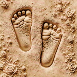 May include: Two small, bare footprints pressed into a light brown, textured surface. The surface is decorated with raised, floral designs.