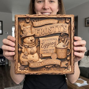 May include: A square wooden sign featuring a carved snowman wearing a top hat, a mug of eggnog, and banners with the text: Welcome to Frosty's, Old Fashioned Eggnog, Made Fresh Daily, 10 cents, Ice Cold Eggnog, Merry Christmas, Warm Hearts Happy Memories.