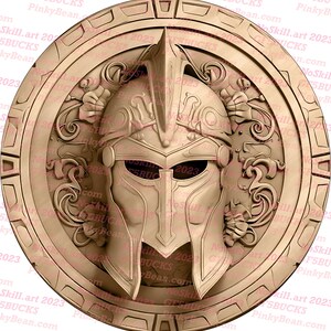 May include: A gold-colored round shield with an ornate design featuring a raised, detailed, sculpted image of a warrior's helmet in the center. The shield has a raised rim and a textured surface.