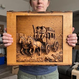 May include: A rectangular wooden plaque featuring a detailed relief carving of a stagecoach pulled by two horses. The scene depicts two figures seated on the coach in a desert landscape under a starry sky. The plaque has a natural live edge border.