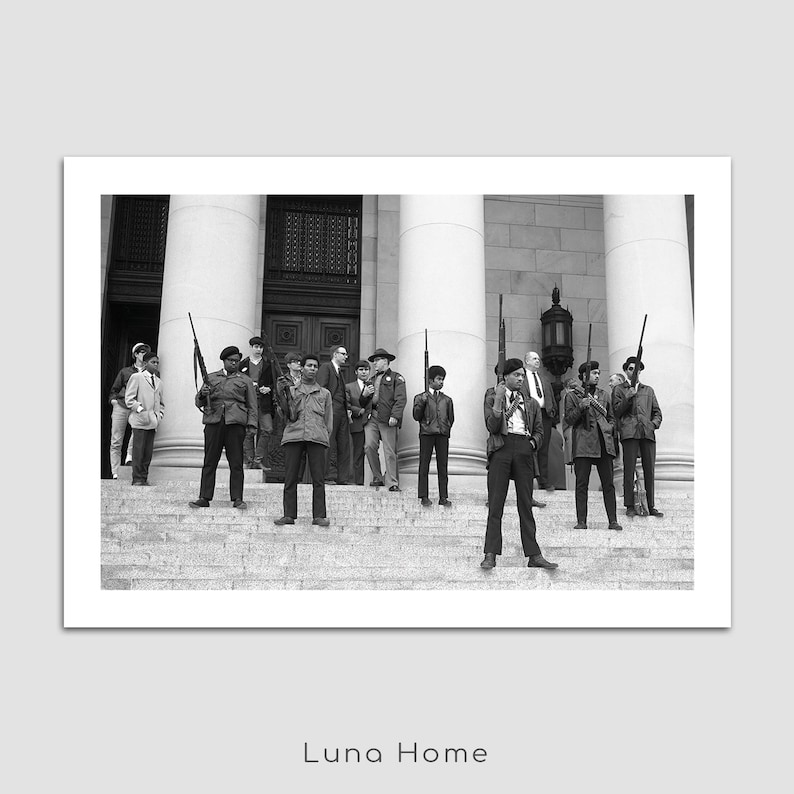 May include: Black and white photograph of a group of people standing on steps in front of a building with large columns. Many are holding rifles. The image is a print from Luna Home.