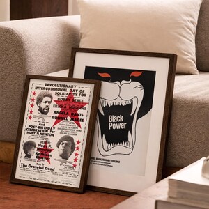 Pu&ograve; includere: Due poster incorniciati con cornici in legno scuro. Un poster presenta una grafica di pantera nera con le parole "Black Power". L'altro poster ha testo su un evento rivoluzionario con ritratti e le parole "The Grateful Dead".