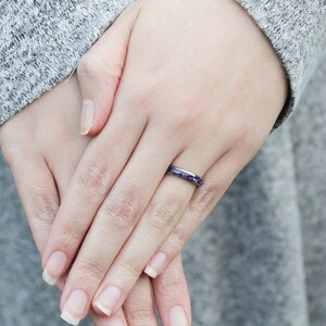May include: A thin silver band ring with a purple glitter inlay.