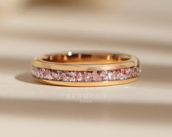 Könnte beinhalten: Ein Goldring mit einer Reihe kleiner rosa Kristalle, die in die Band eingefasst sind. Redwood Rings.