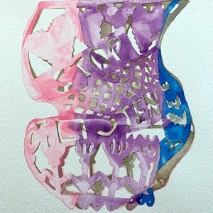 May include: Watercolour painting of a cutout design in pink, purple, and blue. The design is intricate and features a variety of shapes, including hearts, flowers, and geometric patterns.