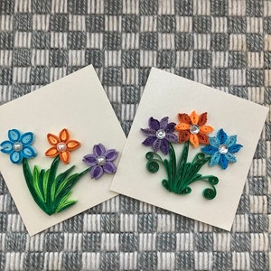 Conjunto de dois cartões de papel quilled com três flores lindamente coloridas. Eles medem 4" por 4" cada e vêm com um envelope correspondente.