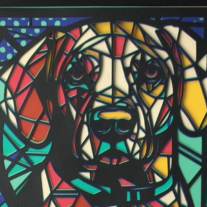 May include: A colorful paper cut-out of a dog's head. The dog is made of red, yellow, white, and blue paper. The background is a blue and white polka dot pattern.