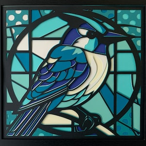 May include: A blue and white bird with a long tail is depicted in a stained glass style. The bird is surrounded by a geometric pattern of blue, green, and white glass pieces.
