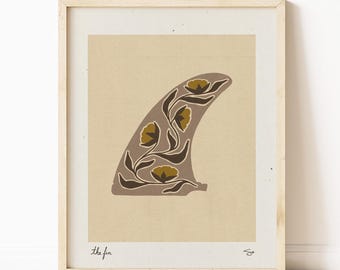 May include: A framed print of a brown surfboard fin with a floral design in shades of brown and yellow. The text "the fin" is printed below the image.