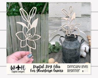 May include: A wooden cutout of a lily flower, ideal for crafting projects. The cutout is shown in a hand and also displayed in a rustic setting. The text "Digital SVG files for Glowforge lasers" and "Difficulty level: beginner" is also included in the image.