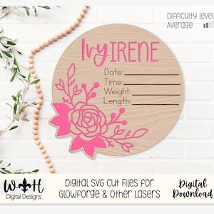 Könnte beinhalten: Ein rosa-brauner Holz-Kreis mit dem Namen "Ivy Irene" und Platz zum Ausfüllen von Datum, Uhrzeit, Gewicht und Länge. Der Kreis ist mit einem rosa floralen Design verziert.