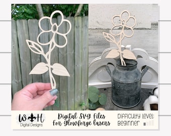 May include: A wooden cutout of a flower with five petals and two leaves. The flower is on a stick and is being held by a hand. The text "Digital SVG files for Glowforge lasers" and "Difficulty level: beginner" is visible at the bottom of the image.