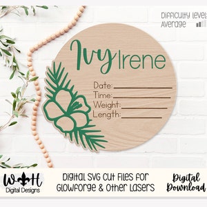 Könnte beinhalten: Ein rundes Holzschild mit einem grünen Blumenmuster und dem Namen "Ivy Irene" in Kursivschrift. Das Schild hat leere Zeilen für Datum, Uhrzeit, Gewicht und Länge. Das Schild ist perfekt für eine Babyparty oder das Kinderzimmer eines Neugeborenen.