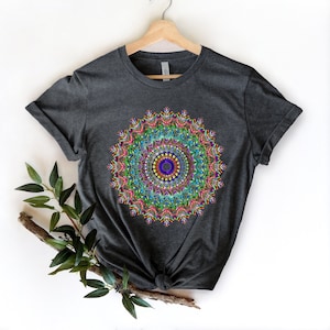 May include: A dark gray t-shirt with a colorful mandala design printed on the front. The mandala features a variety of colors, including pink, blue, green, and yellow.