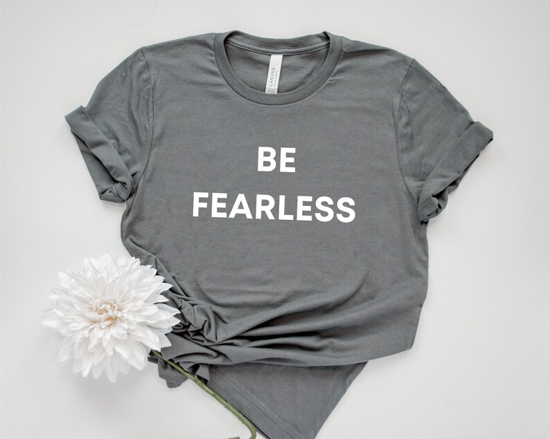 May include: A grey t-shirt with the text "BE FEARLESS" printed in white on the front.