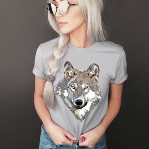 May include: A gray t-shirt with a graphic of a wolf's face in shades of gray, brown, and white.