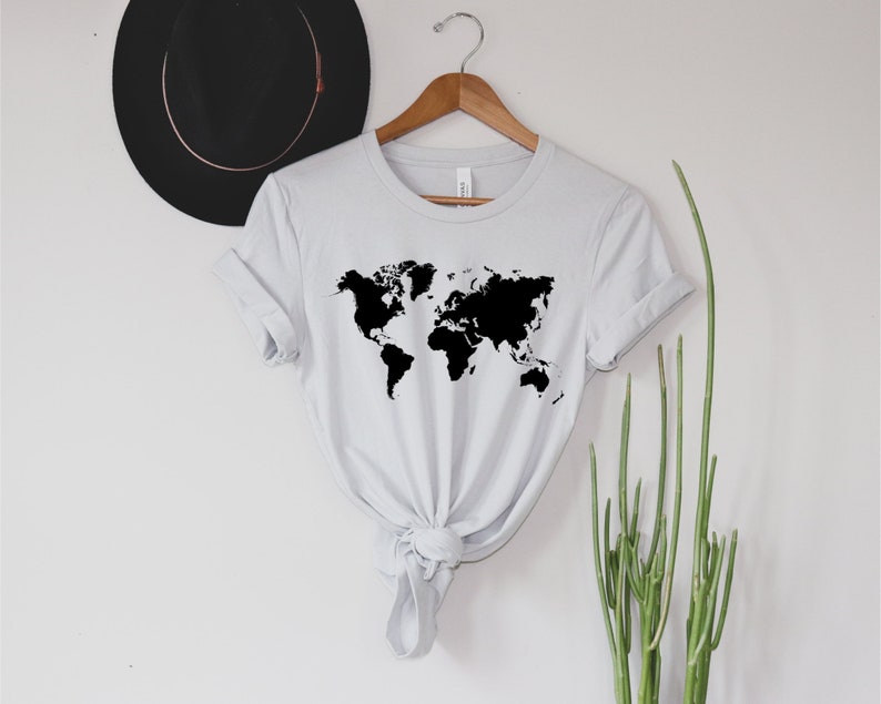May include: A white t-shirt with a black outline of the world map printed on the front.