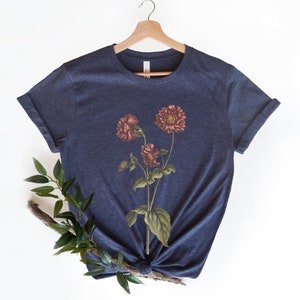 May include: A navy blue t-shirt with a vintage floral print featuring three red flowers with green leaves.