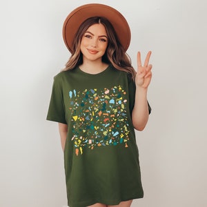 Pu&ograve; includere: Una maglietta verde con un motivo a coriandoli colorati. La maglietta ha una vestibilit&agrave; rilassata e un collo rotondo.