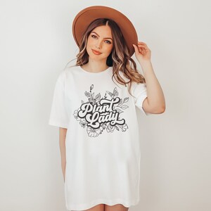 May include: White t-shirt with a black and white graphic design of flowers and the text "Plant Lady" in a retro font.