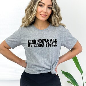 May include: Gray t-shirt with black text that reads "Kind people are my kinda people" in a retro font.