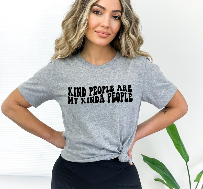 May include: Gray t-shirt with black text that reads "Kind people are my kinda people" in a retro font.
