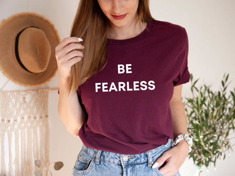 May include: A maroon t-shirt with white text that reads "BE FEARLESS".