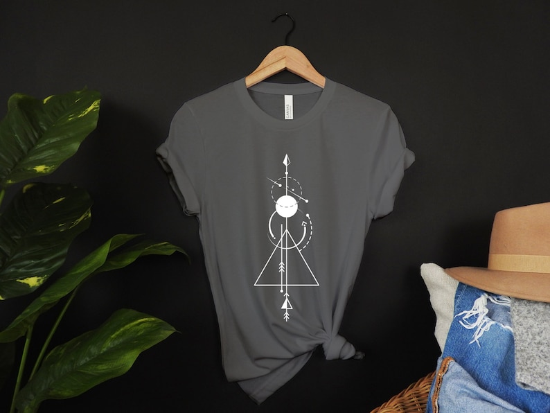 A short sleeve t shirt with a white abstract shapes design. The shirt is the Bella Canvas 3001 unisex jersey tee. Available in many colors and sizes. Very soft and high quality shirt. Sleeves can be rolled up.