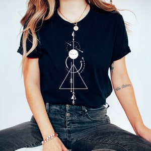 May include: A black t-shirt with a white geometric design featuring a triangle, circle, and arrows. The design is centered on the shirt.
