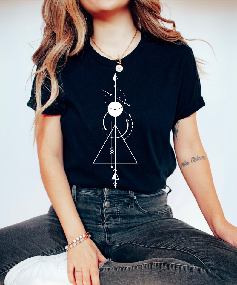 May include: A black t-shirt with a white geometric design featuring a triangle, circle, and arrows. The design is centered on the shirt.