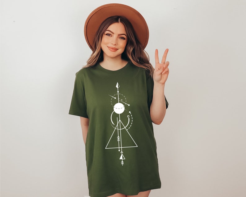 May include: A green t-shirt with a white geometric design featuring a circle, triangle, and arrows. The design is centered on the shirt.