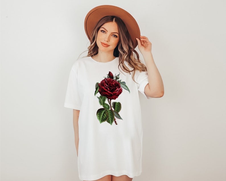 May include: A white t-shirt with a red rose graphic print. The rose has green leaves and a stem.
