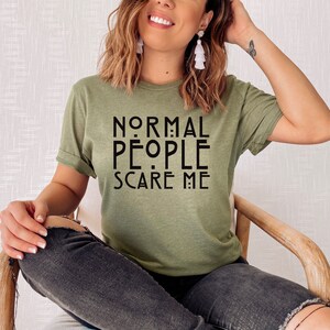 Puede incluir: Una camiseta verde con el texto "NORMAL PEOPLE SCARE ME" en negro.