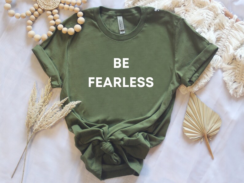 May include: A green t-shirt with the words "BE FEARLESS" printed in white on the front.