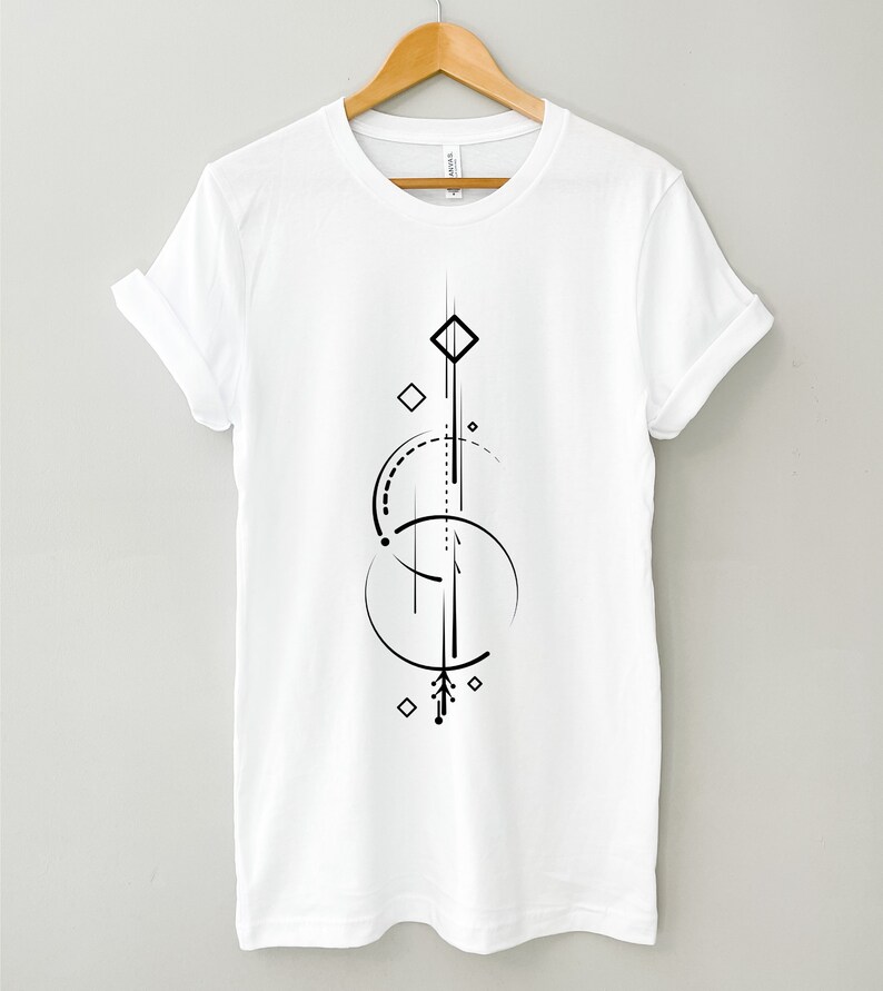 Pode incluir: Camiseta branca com um design geom&eacute;trico preto com c&iacute;rculos, linhas e diamantes.