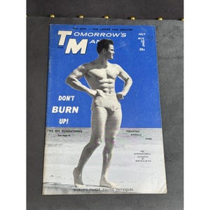 Pode incluir: Uma edição vintage de julho de 1967 da revista Tomorrow's Man com uma capa azul apresentando uma fotografia em preto e branco de uma pessoa musculosa em trajes de banho. O texto diz Tomorrow's Man, Don't Burn Up!, Tips on Sunbathing.