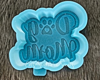 May include: A light blue silicone mould for making resin crafts. The mould is shaped like a cloud and features the text "Dog Mom" with a paw print and heart.